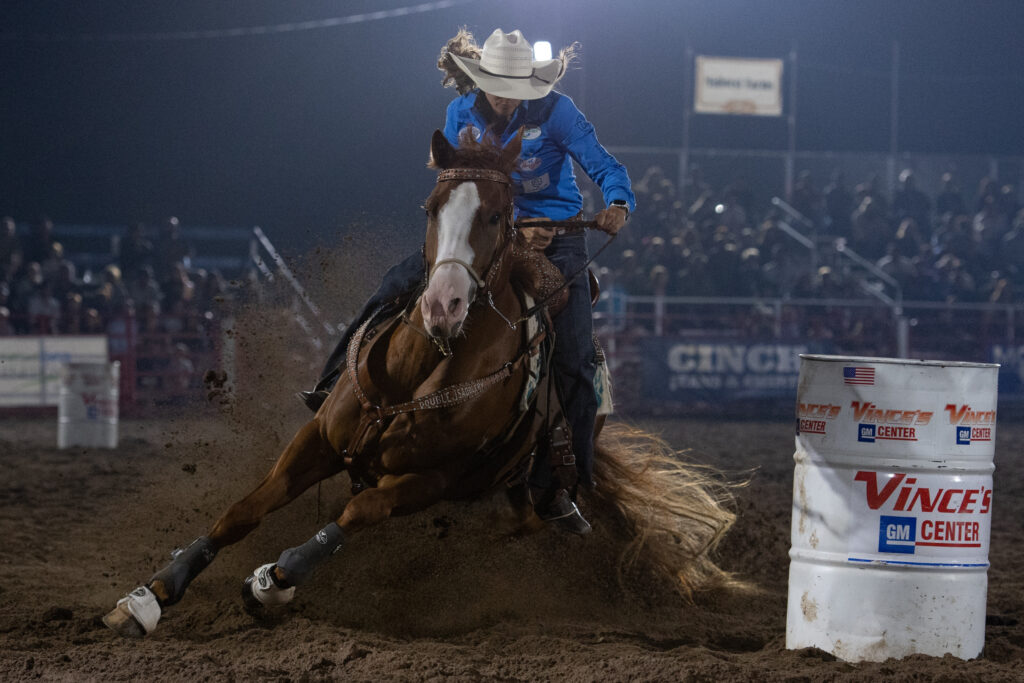 Rock On Guys turns a barrel, rider wears a blue shirt