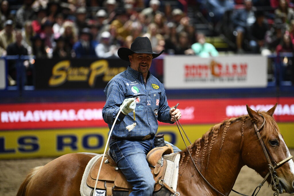 Jake Long smiles while riding Copper, a sorrel gelding with a braided mane, at the 2025 NFR.