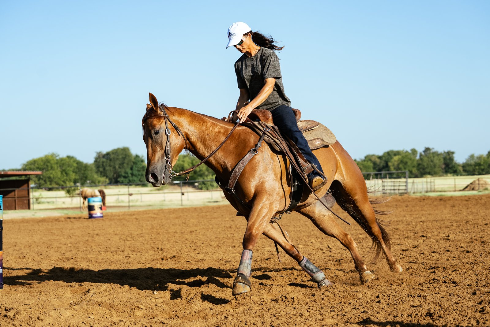 Jolene Montgomery riding a sorrel horse in an outdoor arena
