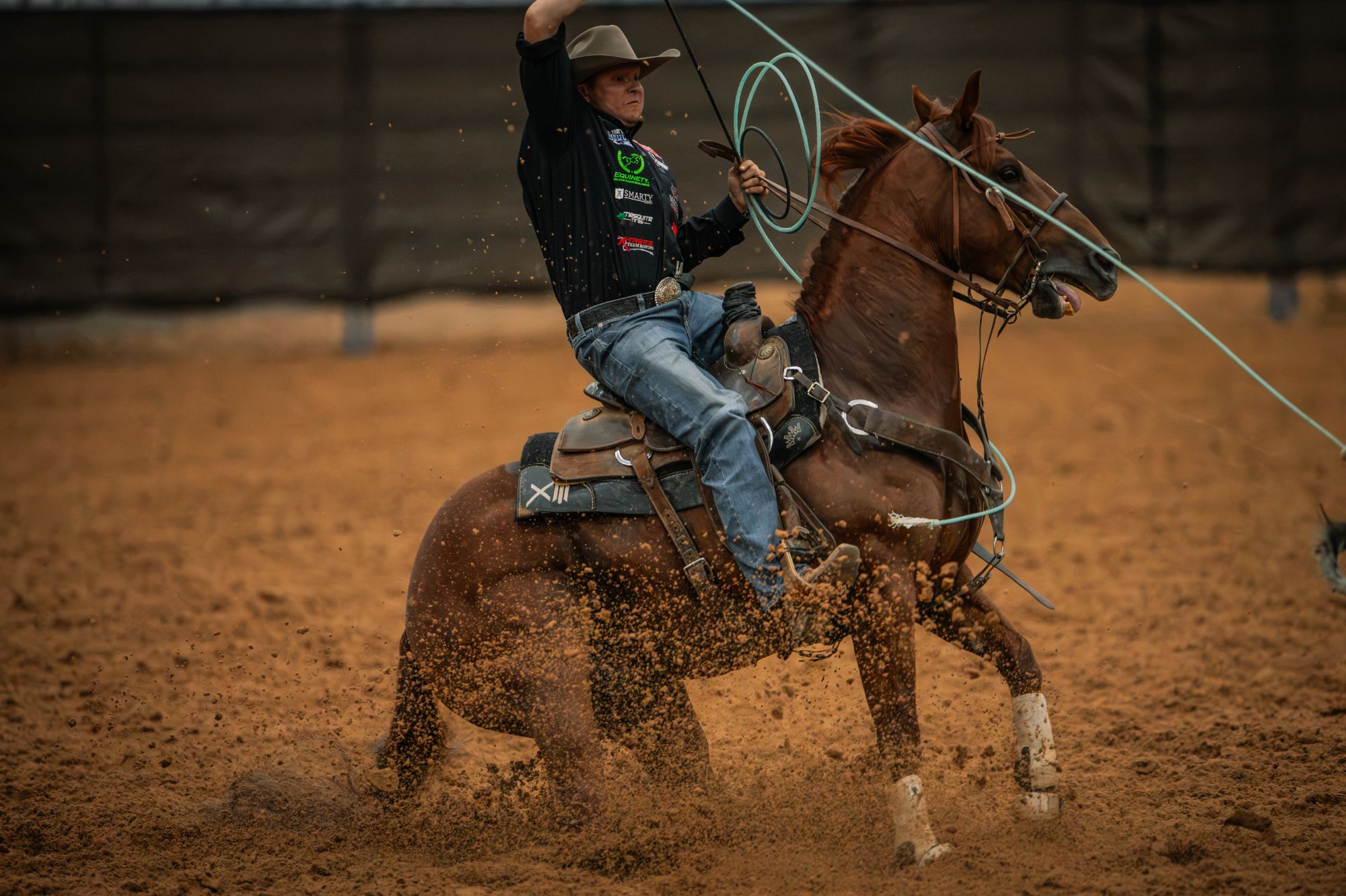 Hunter Koch swings his rope as Rockk Star stops hard in the dirt in Amarillo.